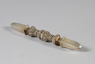 une image représentant un couteau argenté et doré posé sur une surface blanche