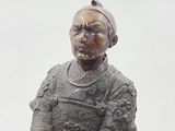 statue of a man in armor holding a sword and a shield