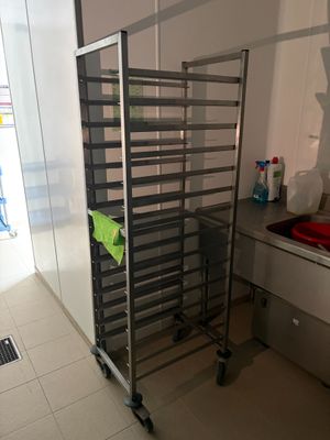 une photo d'une cuisine avec une étagère métallique dans un coin