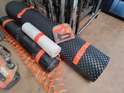 a roll of black and orange construction material on the floor