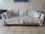 a white couch in a living room with a picture on the wall