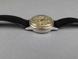 a close up of a watch with a leather strap
