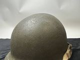 an army helmet on a black cloth with a white background