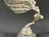 an image of a statue of a winged bird on a pedestal