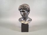bust of a young man with curly hair on a wooden base
