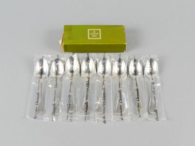 six spoons and a box of silverware sitting on a table
