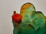 a green glass vase with a red flower on it