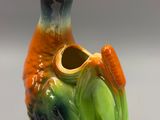 un vase coloré orné d'un oiseau, posé sur une table