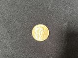 a close up of a gold coin on a black cloth