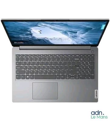 un gros plan d'un ordinateur portable posé sur une surface blanche, avec un fond bleu