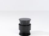 un gros plan d'un bouton noir sur une surface blanche
