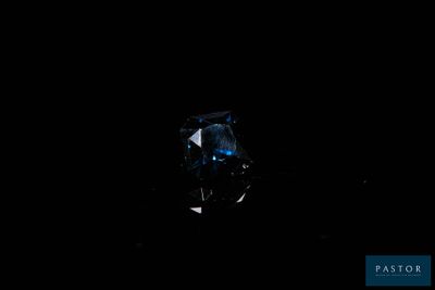 a close up of a blue diamond on a black background