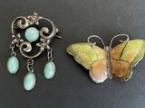 two pieces of jewelry sitting on top of a black surface