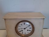 une petite horloge blanche posée sur une table