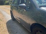 the car is parked on the side of the road in the dirt