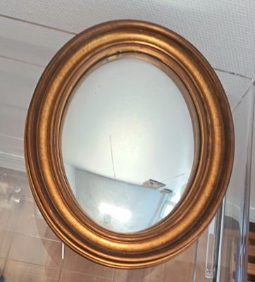 un miroir accroché au mur de la salle de bains