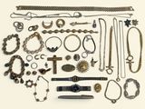 de nombreux types de colliers et de bracelets disposés sur une surface blanche