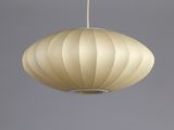 a close up of a white lamp hanging from a ceiling