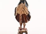 statue of a man with a beard and a hat on a wooden base