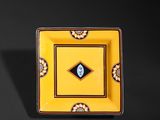 an image of a yellow square plate with a blue eye on it