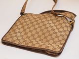beige and brown guccissi bag on a white surface