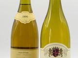 deux bouteilles de vin sont posées l'une à côté de l'autre sur une surface blanche
