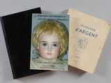 deux livres posés sur une table, avec une poupée à l'intérieur, et un livre posé sur la table