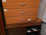 a dresser with a drawer and a pair of shoes on it