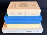 three books stacked on top of each other on a black surface