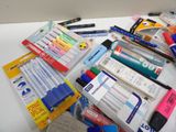 many different pens and pencils laid out on a table
