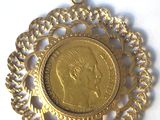 a close up of a gold coin with a chain around it