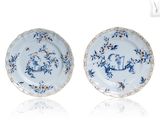 pair of blue and white plates with birds and flowers on them