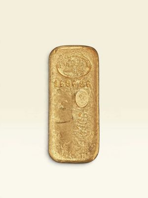 une barre d'or posée sur une surface blanche