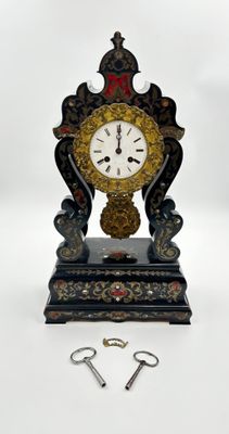 une horloge posée sur une table, à côté d'une paire de ciseaux