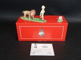 une boîte rouge sur laquelle est représentée une figurine représentant un homme et un chien