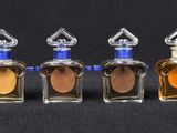 three small bottles of perfume are lined up on a black surface