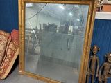 un miroir posé par terre à côté d'une chaise