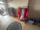 a lot of clothes hanging on a rack in a room