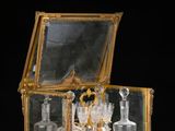 une boîte en or et en verre contenant de nombreuses bouteilles