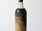 an old bottle of wine sitting on top of a wooden table