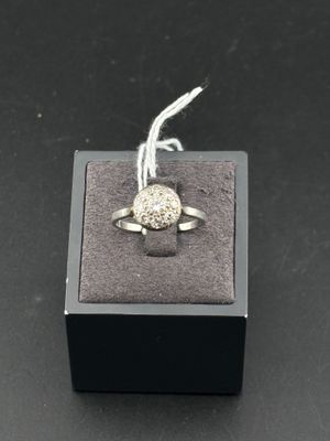gros plan d'une bague en argent sur une surface noire