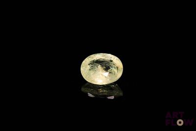 a close up of a yellow diamond on a black surface