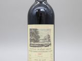 une bouteille de vin rouge posée sur une table blanche
