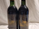two bottles of wine sitting next to each other on a table