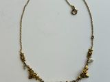 un collier en or orné de petites fleurs sur une chaîne