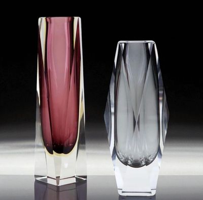 trois vases en verre de couleurs différentes posés les uns à côté des autres sur une table