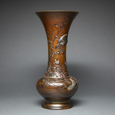 a bronze vase with birds and flowers on it