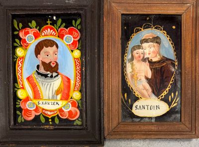 two framed pictures of a man and a woman are on a wall