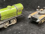 two toy trains sitting next to each other on a black surface