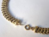 an image of a gold bracelet on a white surface